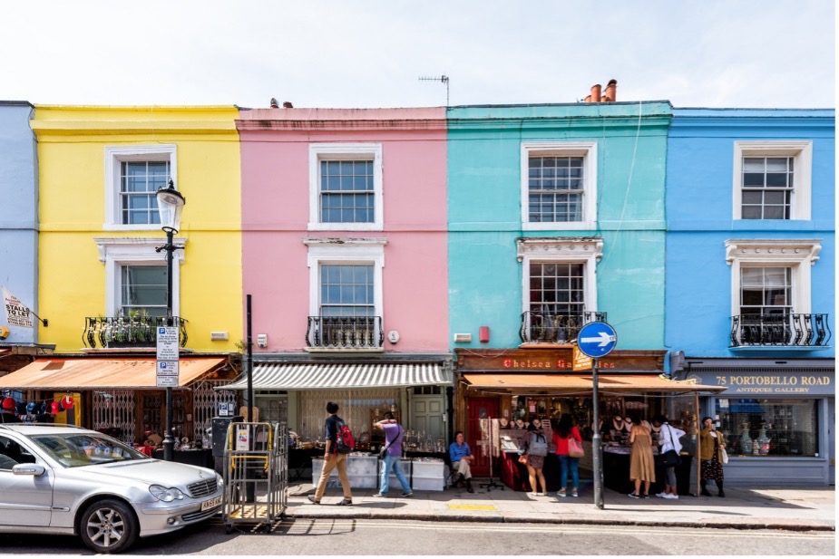 A multicoloured building with people walking on the street